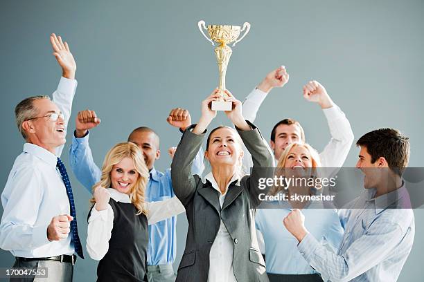 cheerful group of businesspeople winning the cup. - winning prize stock pictures, royalty-free photos & images