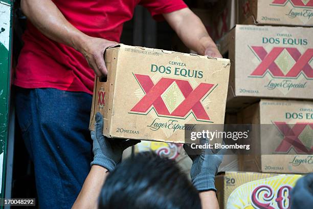 Workers unload cases of Grupo Modelo SAB's Dos Equis brand beer from a truck operated by Cuauhtemoc-Moctezuma, a subsidiary of Heineken NV, while...