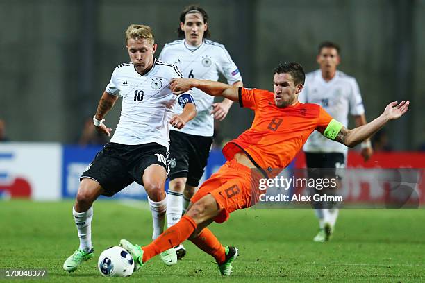 Lewis Holtby of Germany is challenged by Kevin Strootman of Netherlands during the UEFA European Under 21 Championship match between Netherlands and...