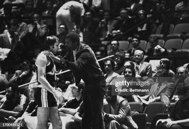 Bill Russell, coach of the Seattle Supersonics, speaking with player Dick Snyder during a game against the New York Knickerbockers, New York,...