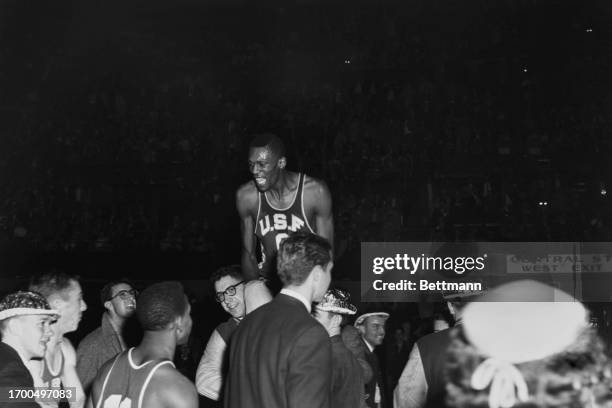 Bill Russell, of the University of San Francisco, is carried on supporters' shoulders after his team defeated La Salle in the final of the NCAA...