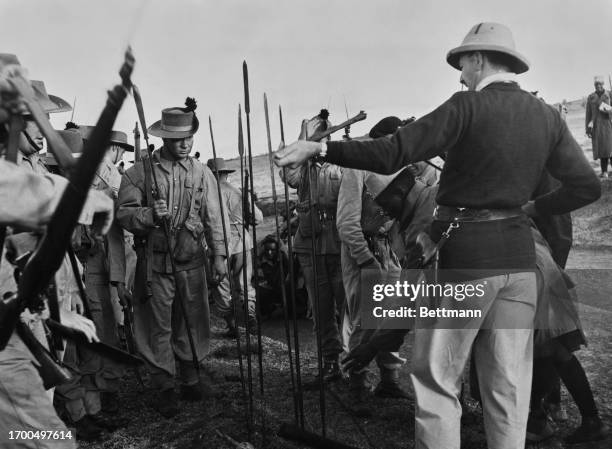 Soldiers examine spears seized during the recent capture of suspected Mau Mau fighters in Kenya, circa 1952. The police, supported by the troops of...