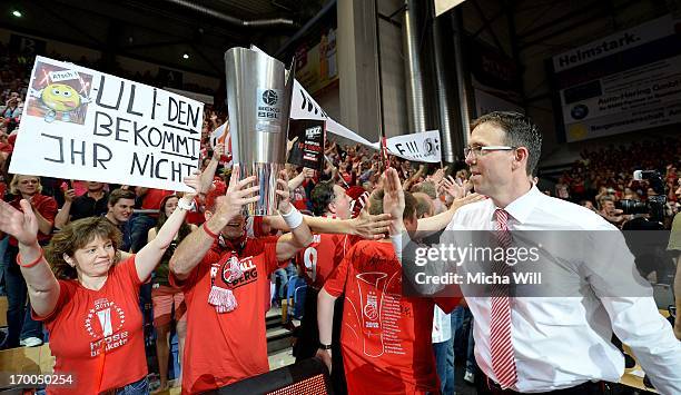 Head coach Chris Fleming of Bamberg gives high fives to the fans and walks passt a replica of the Beko BBL Cup after game 5 of the semifinals of the...