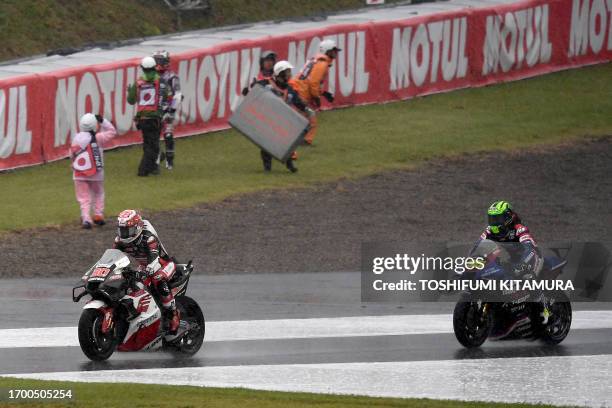 Honda IDEMITSU rider Takaaki Nakagami of Japan and Yamalube RS4GP Racing Team rider Cal Crutchlow of Great Britain go into the pit road while course...