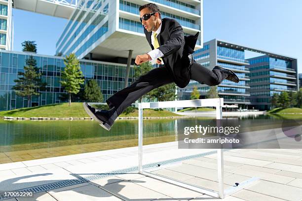 business man over hurdle near offices - center athlete stock pictures, royalty-free photos & images