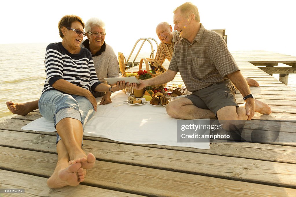 Seniors having fun during picnic on jetty