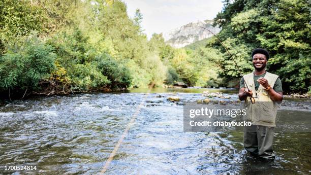 smiling fisherman caught a fish - trout fishing stock pictures, royalty-free photos & images