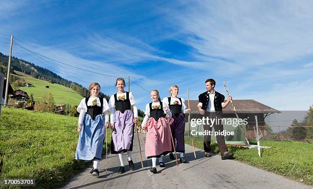 schweizer farmer familie in traditioneller kleidung zu fuß auf die berge - traditionelle kleidung stock-fotos und bilder