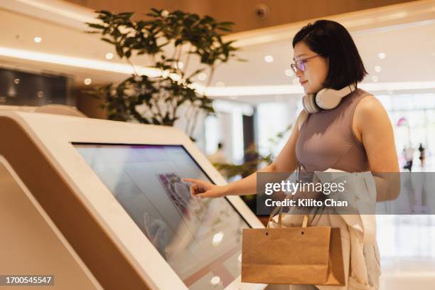 asian woman using interactive directory guide in a shopping mall - touch screen map stock pictures, royalty-free photos & images
