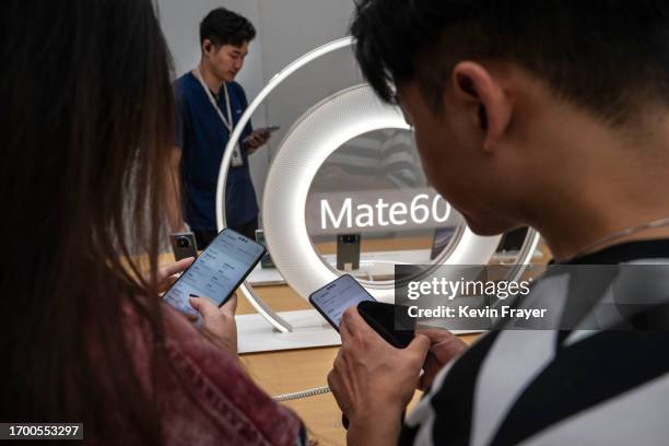 People look at the new Mate 60 smartphone and other products at a Huawei flagship store after the company unveiled new products on September 25, 2023...