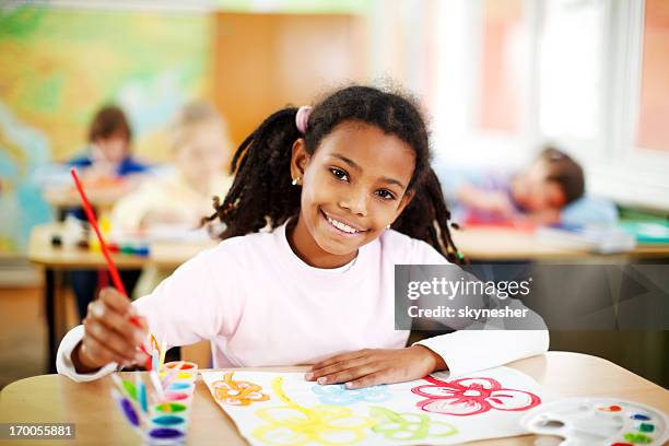 cute african-american girl is painting with watercolors. - child art stockfoto's en -beelden