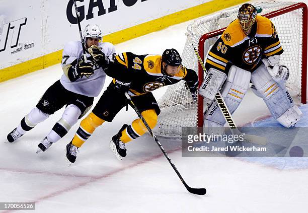 Dennis Seidenberg of the Boston Bruins skates with the puck as Sidney Crosby of the Pittsburgh Penguins defends during Game Three of the Eastern...