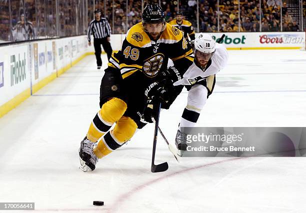 Rich Peverley of the Boston Bruins and James Neal of the Pittsburgh Penguins race for a loose puck during Game Three of the Eastern Conference Final...