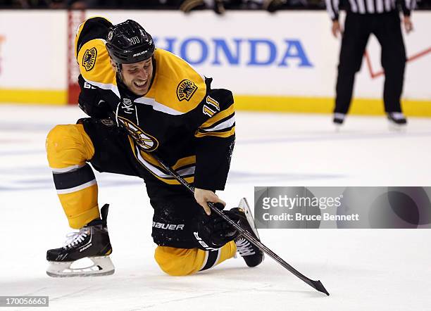 Gregory Campbell of the Boston Bruins reacts after being hit by a shot from the Pittsburgh Penguins during Game Three of the Eastern Conference Final...