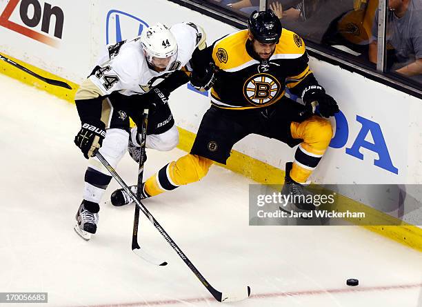 Brooks Orpik of the Pittsburgh Penguins and Milan Lucic of the Boston Bruins battle for a loose puck during Game Three of the Eastern Conference...