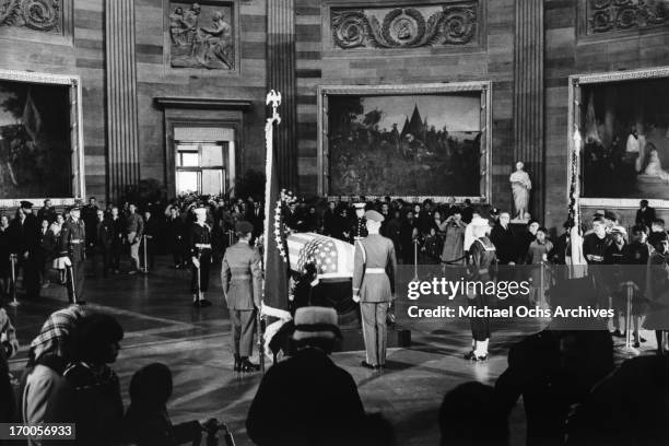 Mourners file by the flag draped coffin of assassinated President John F. Kennedy lying in state in the Capitol rotunda on November 24, 1963 in...