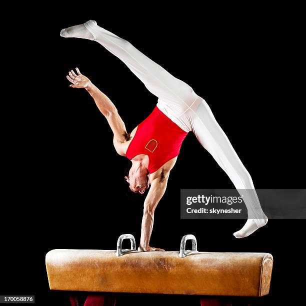 young sportsman exercising on pommel horse. - male gymnast stock pictures, royalty-free photos & images