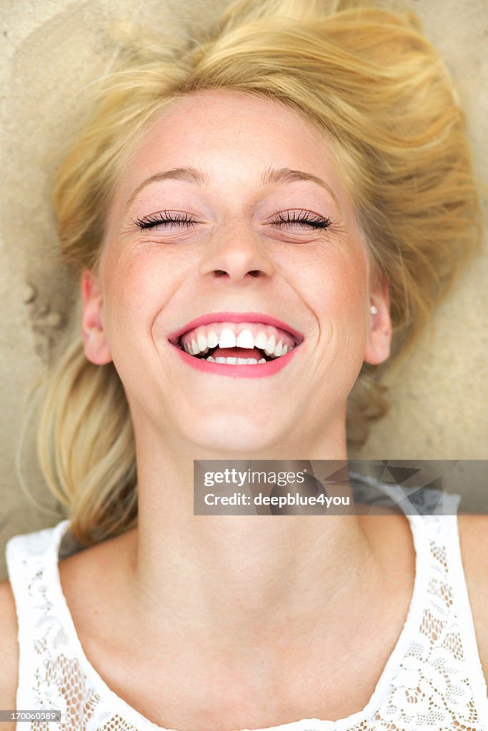 Laughing young woman on the beach