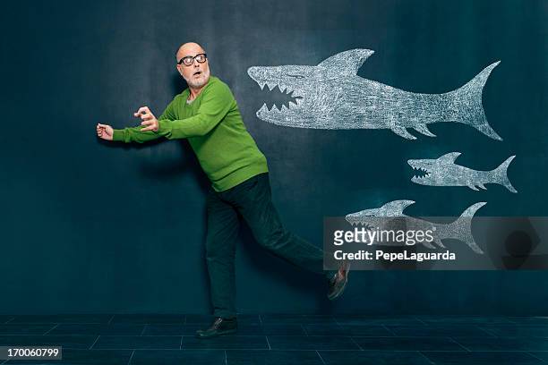terrified man escaping from sharks - evasion fiscale stockfoto's en -beelden