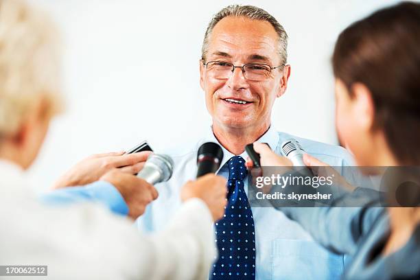 mature man executive being questioned by journalists. - holds federal convention stock pictures, royalty-free photos & images