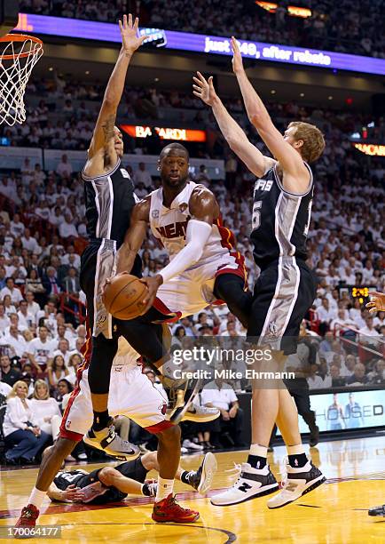 Dwyane Wade of the Miami Heat looks to pass the ball between Danny Green and Matt Bonner of the San Antonio Spurs in the second quarter during Game...