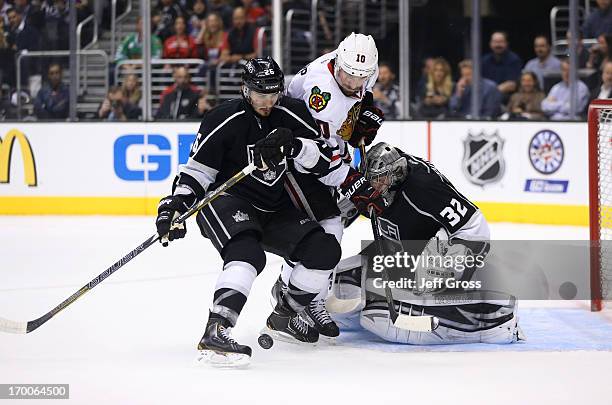 Slava Voynov of the Los Angeles Kings defends the play to the net by Patrick Sharp of the Chicago Blackhawks as goaltender Jonathan Quick of the Los...