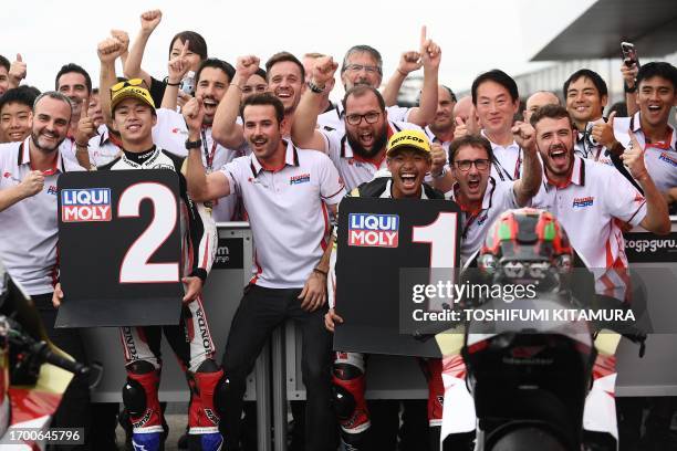 Japanese Grand Prix winner IDEMITSU Honda Team Asia rider Somkiat Chantra of Thailand is celebrated by is celebrated by second placed teammate Ai...