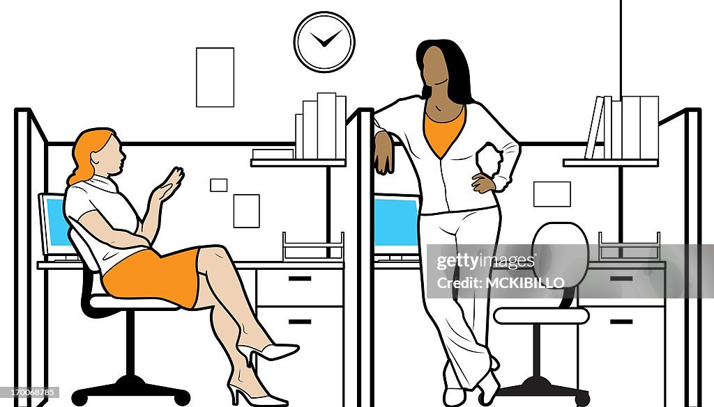 Two women in their office cubicles talking