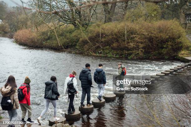 crossing the stepping stones - guided stock pictures, royalty-free photos & images