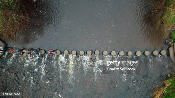 birds eye view of students crossing a river - guided stock pictures, royalty-free photos & images