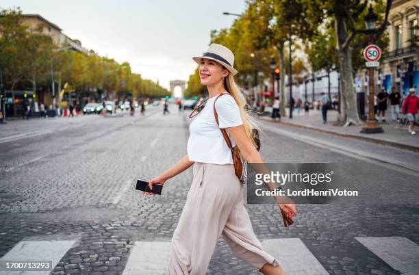 woman walking on champs-elysees avenue in paris - avenue des champs elysees stockfoto's en -beelden
