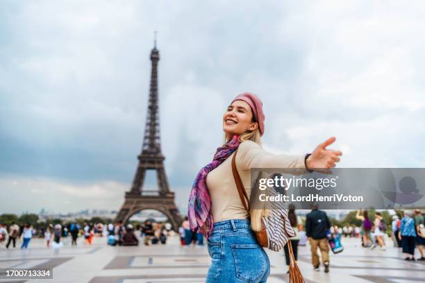 happy woman in front of the eiffel tower in paris - site visit stock pictures, royalty-free photos & images