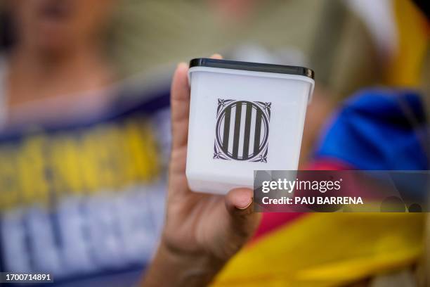 Protestor holds a miniature ballot box during a demonstration marking the sixth anniversary of a self-determination referendum organised by Catalan...