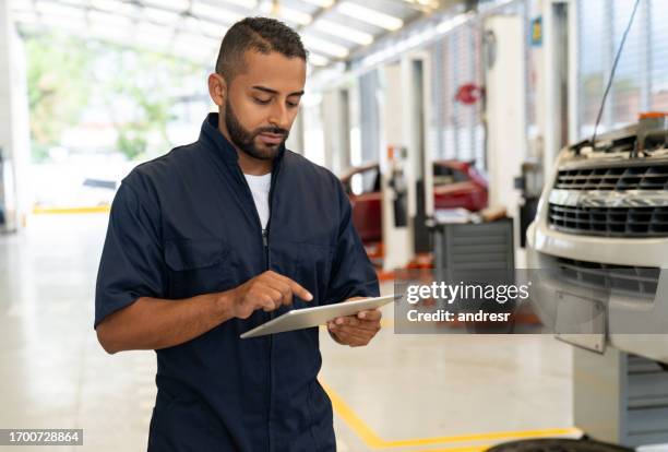 mechanic using a scanner while diagnosing a problem with a car - auto mechanic stock pictures, royalty-free photos & images