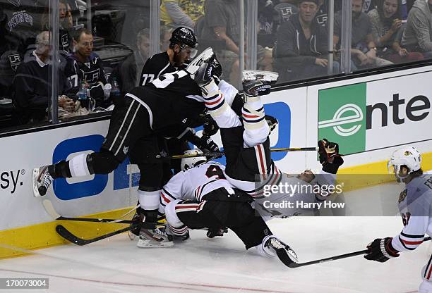 Dustin Penner of the Los Angeles Kings checks Brent Seabrook of the Chicago Blackhawks near the end boards in the third period of Game Four of the...