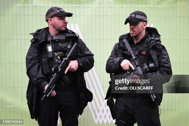 Armed police officers patrol in the streets outside the venue hosting the opening day of the annual Conservative Party Conference in Manchester,...