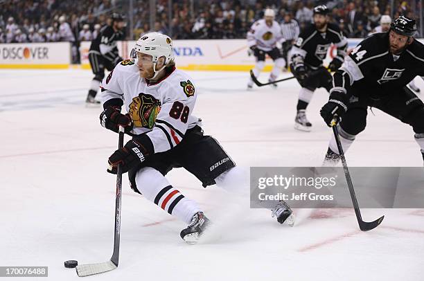 Patrick Kane of the Chicago Blackhawks turns away with the puck from defenseman Robyn Regehr of the Los Angeles Kings in the first period of Game...