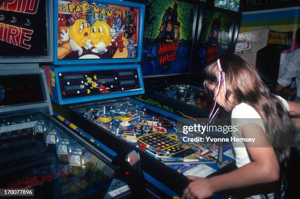 Young girl is photographed June 1, 1982 playing Pac-Man at a video arcade in Times Square, New York City.