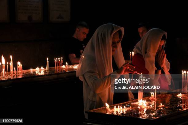 Faithfulls light candles and pray during a service for the Nagorny Karabakh refugees at the Saint-Sargis vicarial church as part of the nationwide...