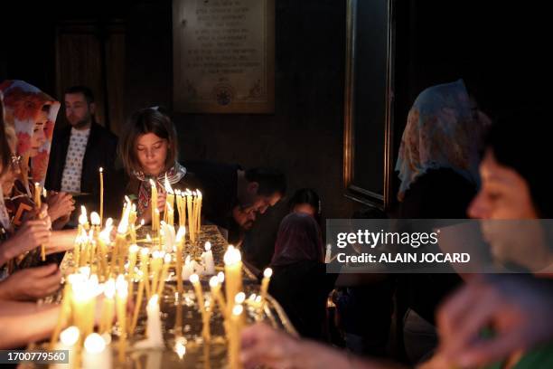 Faithfulls light candles and pray during a service for the Nagorny Karabakh refugees at the Saint-Sargis vicarial church as part of the nationwide...