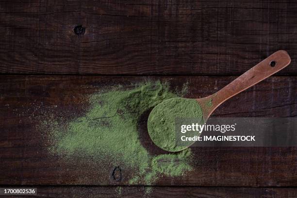 moringa oleifera leaf powder in wooden spoons: a nutritious alternative - moringa oleifera stockfoto's en -beelden