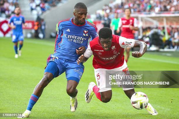 Lyon's Angolan Belgian defender Clinton Mata fights for the ball with Reims' Zimbabwean midfielder Marshall Nyasha Munetsi during the French L1...