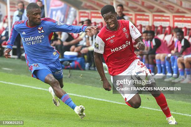 Lyon's Angolan Belgian defender Clinton Mata fights for the ball with Reims' Zimbabwean midfielder Marshall Nyasha Munetsi during the French L1...