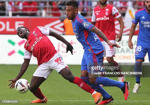 Reims' Zimbabwean midfielder Marshall Nyasha Munetsi fights for the ball with Lyon's French midfielder Corentin Tolisso during the French L1 football...