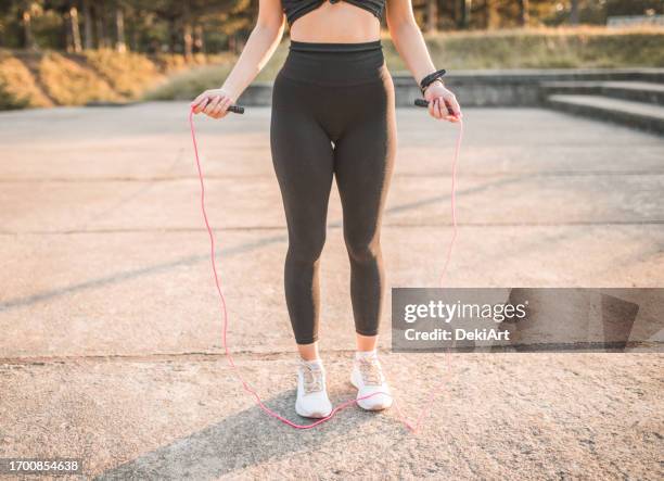 nahaufnahme der hände einer sportlichen jungen frau, die ein springseil hält - seilspringen stock-fotos und bilder