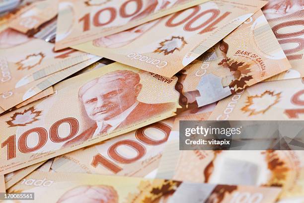 pile of canadian $100 bills issued in 2012 - canadian money stock pictures, royalty-free photos & images