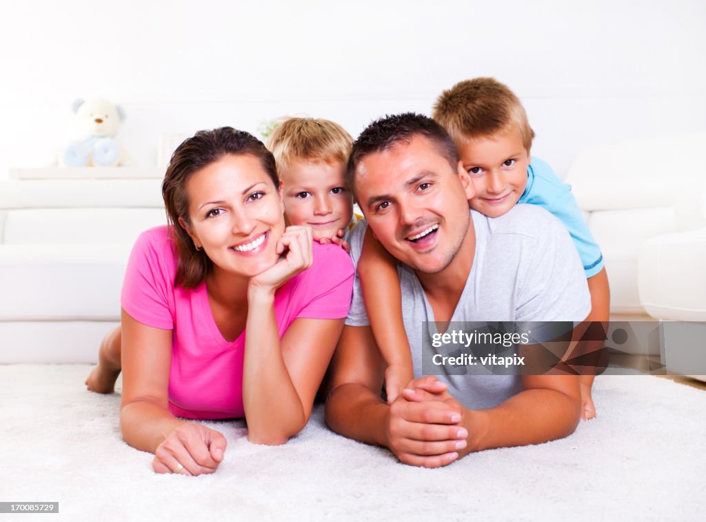 Family lying down on white livingroom floor