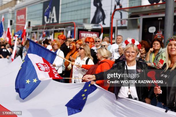 Demonstrators wave the EU and the Polish flag as they gather for the 'Million Hearts March', organised by the opposition, at Marszalkowska Street in...