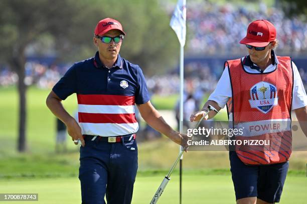 Golfer, Rickie Fowler and his caddie, Ricky Romano on the 2nd green during his singles match against Europe's English golfer, Tommy Fleetwood on the...