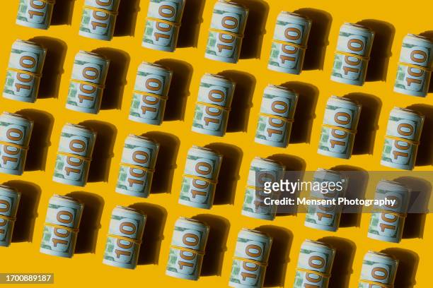 abstract pattern in roll of american dollars banknotes on the yellow background - canadian one hundred dollar bill 個照片及圖片檔